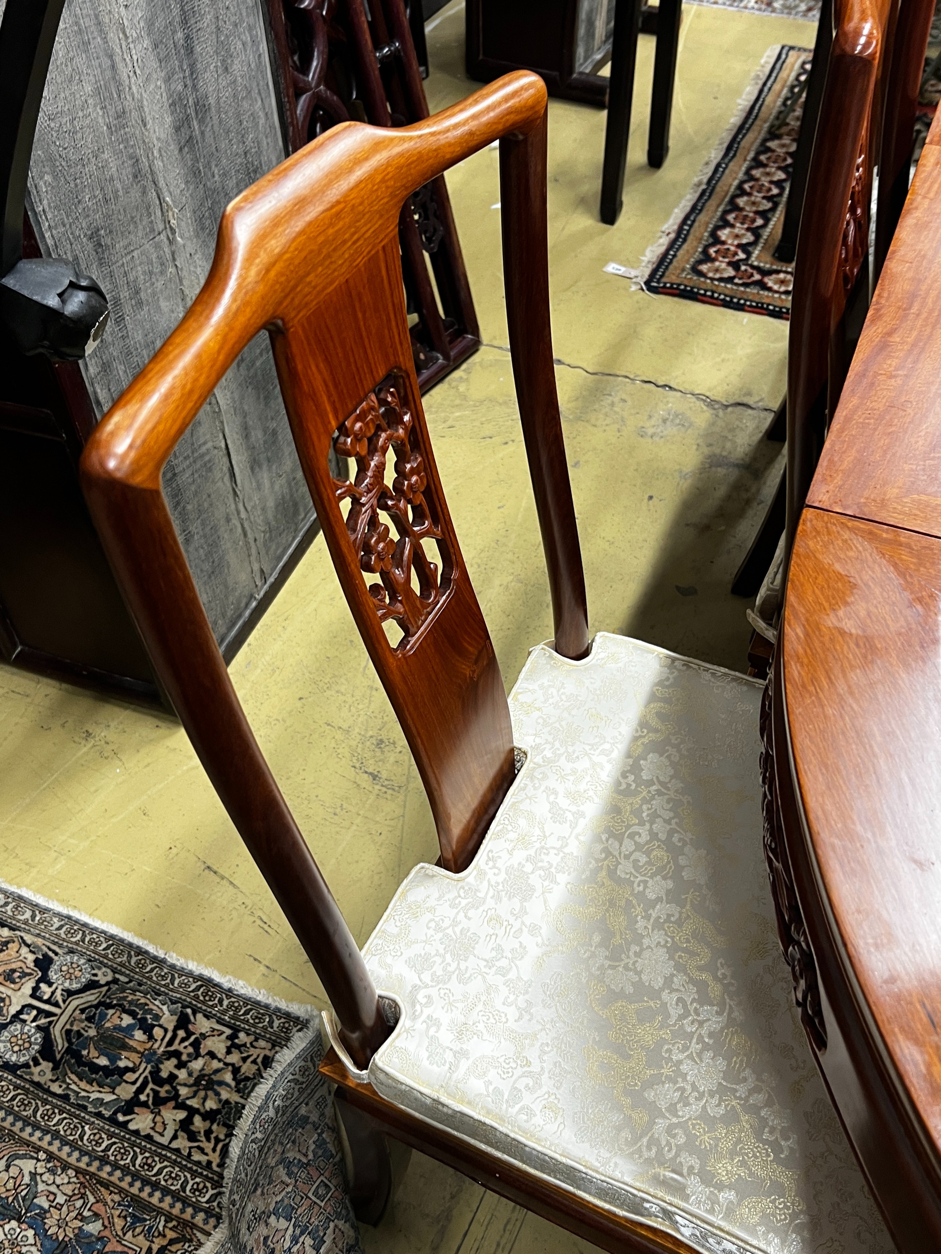 A Chinese hardwood extending dining table, length 214cm, width 111cm, height 77cm extended, two spare leaves together with eight chairs (2 with arms)